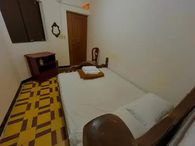 a small bedroom with a bed and a table at Casa Grande Hostal in Medellín