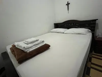 a bed with two towels sitting on top of it at Casa Grande Hostal in Medellín