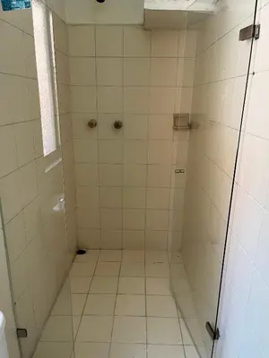 a bathroom with a shower with white tiles at Casa Grande Hostal in Medellín