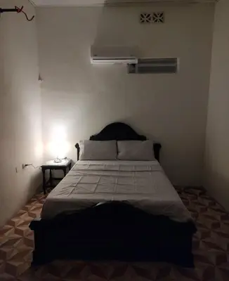 a bedroom with a bed and a night stand with a lamp at SAN SENDERISMO ROOM in Mariquita