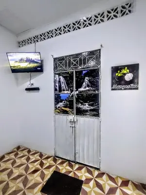 a room with a door and a television on a wall at SAN SENDERISMO ROOM in Mariquita