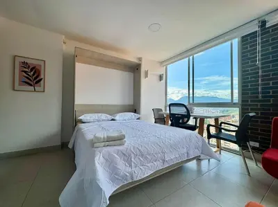a bedroom with a bed and a table with chairs at Apto Familiar in poblado in Medellín