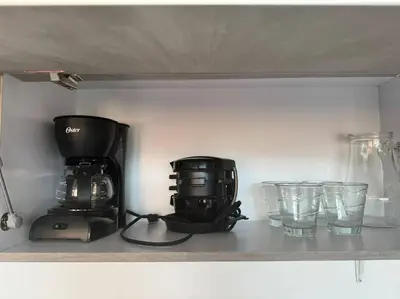 a shelf with a coffee maker and glasses on it at Apto Familiar in poblado in Medellín