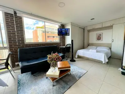 a living room with a couch and a bed at Apto Familiar in poblado in Medellín