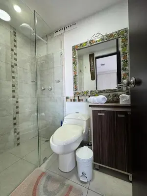 a bathroom with a toilet and a shower and a mirror at Apto Familiar in poblado in Medellín
