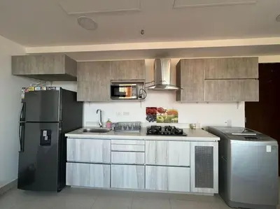 a kitchen with a black refrigerator and a stove at Apto Familiar in poblado in Medellín