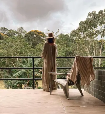 a woman standing on a balcony looking out at the forest at Ceiba del Agua in San Rafael