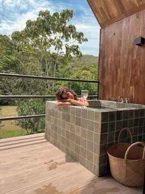 a woman holding a glass of wine in a tub on a deck at Ceiba del Agua in San Rafael