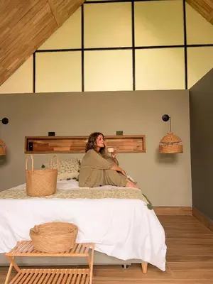 a woman sitting on top of a bed at Ceiba del Agua in San Rafael