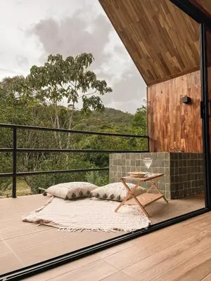 a bedroom with a bed on a deck with a table at Ceiba del Agua in San Rafael