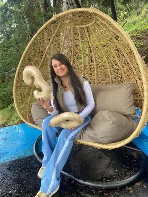 a woman is sitting in a wicker swing at Refugio del Lago in Guatapé