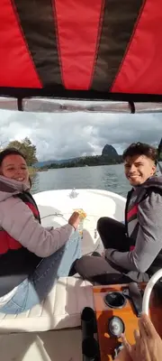 two people sitting on a boat in the water at Refugio del Lago in Guatapé