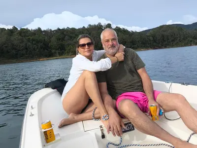 a man and woman sitting on a boat on the water at Refugio del Lago in Guatapé