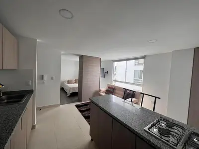 a kitchen with a counter and a living room at Cómodo apartaestudio in Manizales