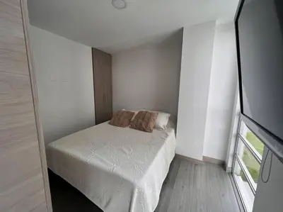 a bedroom with a bed with two pillows on it at Cómodo apartaestudio in Manizales