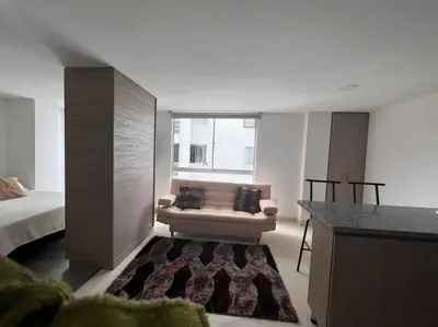 a living room with a couch and a bed at Cómodo apartaestudio in Manizales