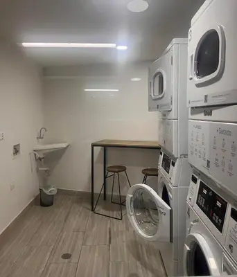 a laundry room with washing machines and a table at Cómodo apartaestudio in Manizales
