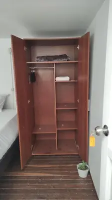 a wooden closet in a room with a bed at Habitación sencilla y central #6 in Medellín