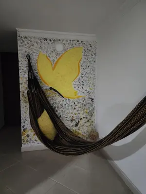 a hammock in front of a wall with a painting at Habitación en apartamento compartido en Envigado in Envigado