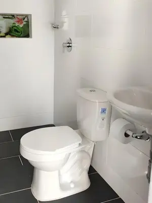 a white bathroom with a toilet and a sink at CASA ESTADIO MEDELLIN Amplio Apartamento Renovado para Familias, Grupos o Delegaciones Deportivas cerca al Estadio Atanasio Girardot - Laureles-Estadio in Medellín