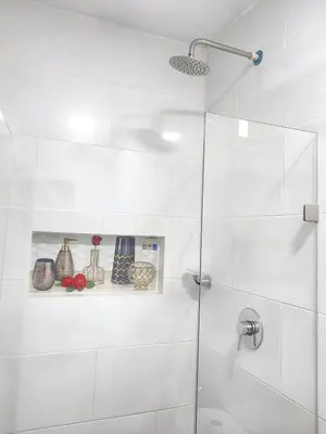 a white bathroom with a shower with a glass door at CASA ESTADIO MEDELLIN Amplio Apartamento Renovado para Familias, Grupos o Delegaciones Deportivas cerca al Estadio Atanasio Girardot - Laureles-Estadio in Medellín