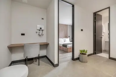 a room with a bed and a table and a mirror at Apartamentos HOUSY Laureles in Medellín