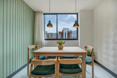 a dining room with a table and chairs and a window at Apartamentos HOUSY Laureles in Medellín