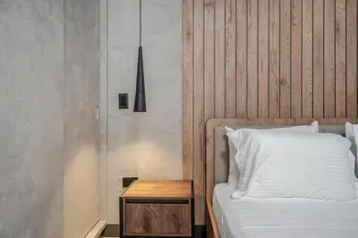 a bed with a wooden headboard and a wooden table at Apartamentos HOUSY Laureles in Medellín
