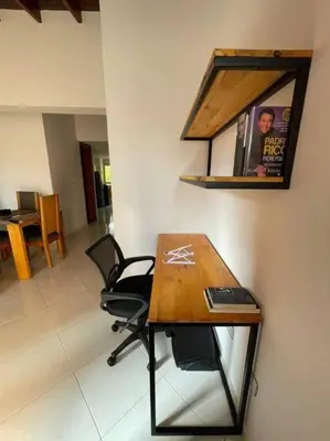 a desk with chairs and a picture on a wall at Ideal para grupos y nómadas Apto 2 hab amplio in Sabaneta