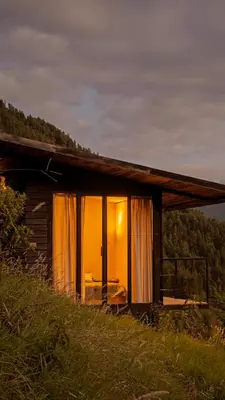 a small cabin with a bed in the window at Ecolodge Cuentos de Agua in Villamaría