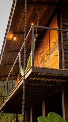 a porch of a house with a swing at Ecolodge Cuentos de Agua in Villamaría