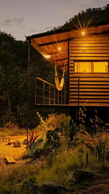a house with a porch with lights on it at Ecolodge Cuentos de Agua in Villamaría