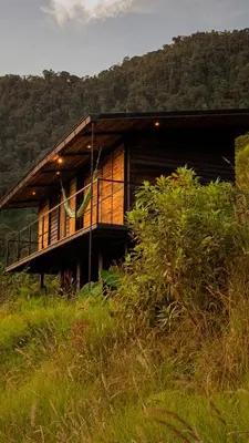 a house on top of a hill in a field at Ecolodge Cuentos de Agua in Villamaría