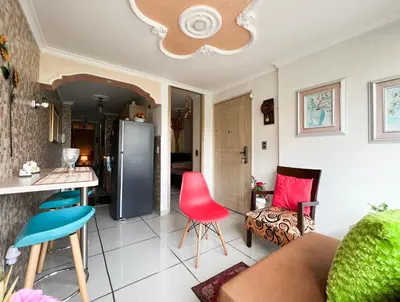 a kitchen and living room with a refrigerator and chairs at Elegante apartamento: Sabaneta Central in Sabaneta