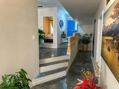 a hallway of a home with stairs and plants at Villa Athenea-Santorini Colombiano in Puerto Triunfo