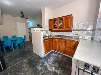 a kitchen with wooden cabinets and blue chairs at Villa Athenea-Santorini Colombiano in Puerto Triunfo