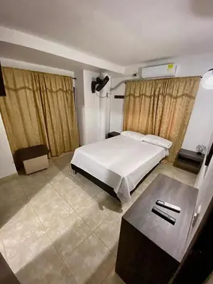 a bedroom with a bed and a table in it at Villa Athenea-Santorini Colombiano in Puerto Triunfo