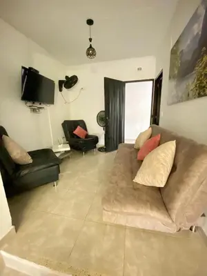a living room with a couch and a tv at Villa Athenea-Santorini Colombiano in Puerto Triunfo