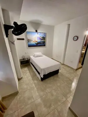 a bedroom with a bed and a painting on the wall at Villa Athenea-Santorini Colombiano in Puerto Triunfo