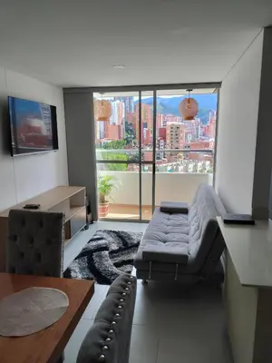 a living room with a couch and a large window at Apartamento Sabaneta Antioquía in Sabaneta
