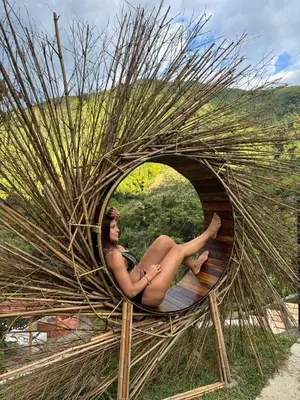 a woman is sitting in a nest of sticks at Cabaña campestre para parejas o grupos in Manizales