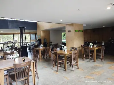 a dining room with wooden tables and chairs at Hotel en Rionegro-Rioverde- Apartamento in Rionegro
