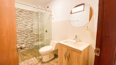 a bathroom with a toilet and a sink and a mirror at OCASSO JARDIN APARTAMENTO TURPIAL in Jardin