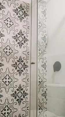 a shower with a black and white tile at OCASSO JARDIN APARTAMENTO TURPIAL in Jardin