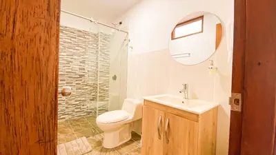 a bathroom with a toilet and a sink and a mirror at OCASSO JARDIN APARTAMENTO TURPIAL in Jardin