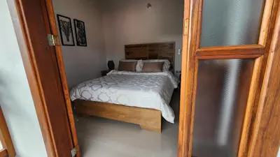 a small bedroom with a bed and a refrigerator at OCASSO JARDIN APARTAMENTO COLIBRÍ in Jardin