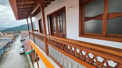 a balcony with a wooden railing and a window at OCASSO JARDIN APARTAMENTO COLIBRÍ in Jardin