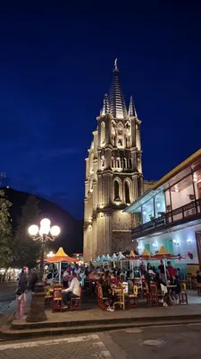 a group of people sitting at tables in front of a building at OCASSO JARDIN APARTAMENTO COLIBRÍ in Jardin