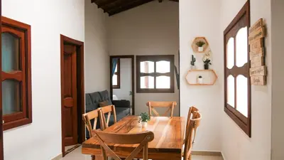 a dining room with a wooden table and chairs at OCASSO JARDIN APARTAMENTO GALLITO DE ROCA in Jardin