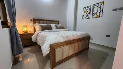 a bedroom with a bed and a night stand with a lamp at OCASSO JARDIN APARTAMENTO GALLITO DE ROCA in Jardin